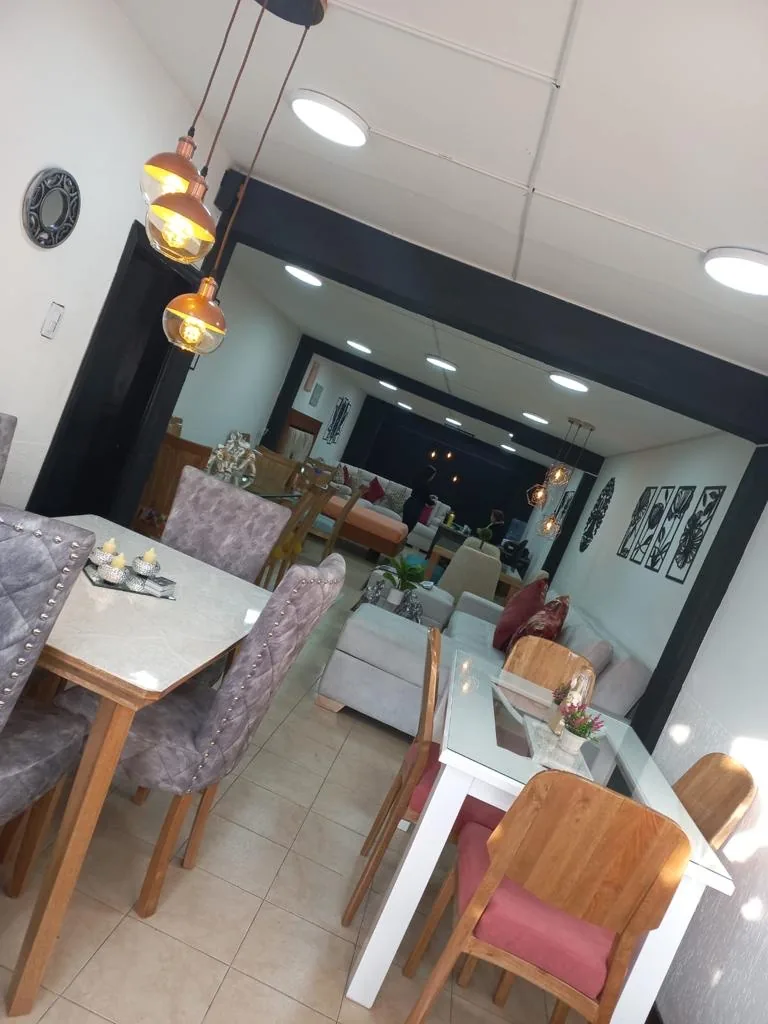 Comedores en madera con sillas tapizadas en el showroom de Mobiliario Cronos